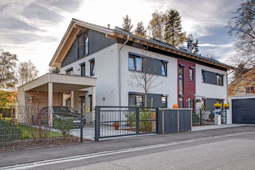 Der Eingang des modernen Zweifamilienhauses aus Holz mit Wintergarten