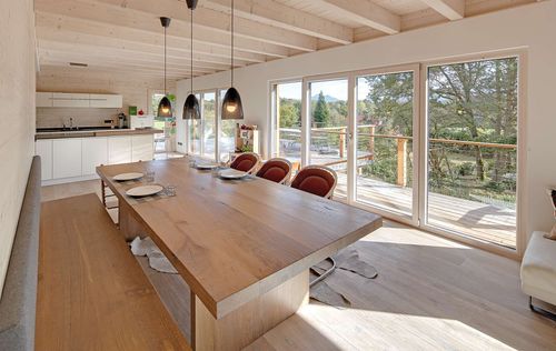 Das Esszimmer des modernen Holzhauses im Landhausstil mit durchgängiger Holzfassade