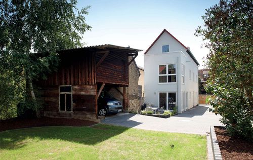 Schmales, modernes Einfamilienhaus mit altem Carport aus Holz