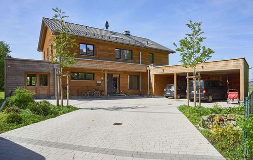 Modernes Holz-Fertighaus mit Satteldach und großem Carport