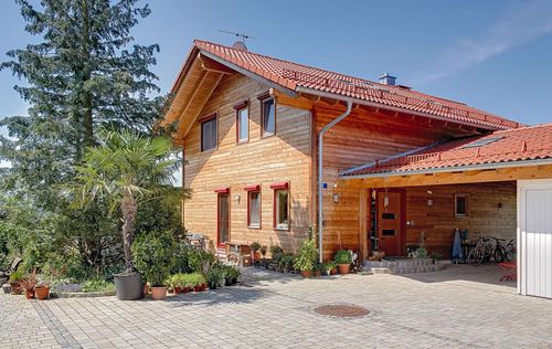 Großzügiges Holzhaus im Landhausstil mit Holzfassade und Erker mit mineralischem Außenputz