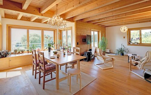 Der Wohn- und Essbereich des großzügigen Holzhauses im Landhausstil mit Holzfassade und Erker mit mineralischem Außenputz