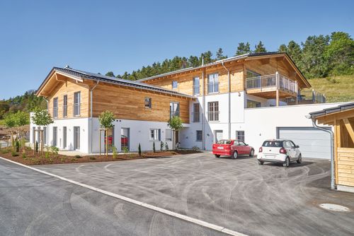 Der Parkplatz des modernen Gewerbebaus aus Holz, Appartementhaus mit 9 Ferienwohnungen
