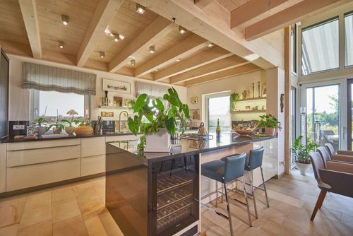 Die Küche des modernen Holzhauses mit Mischfassade aus Holz und Putz und komfortabler Ausstattung