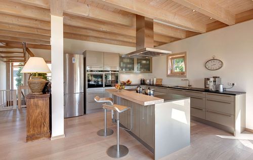 Die Küche des modernen Holzhauses mit umlaufendem Balkon und Mischfassade aus Holz und Putz