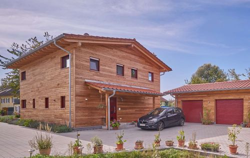 Modernes Holzhaus im Landhausstil mit durchgängiger Lärchenholzfassade und großer Terrasse