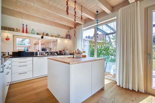 Die Küche des modernen Holzhauses mit Lärchenholzfassade und Fassadenplatten in anthrazit