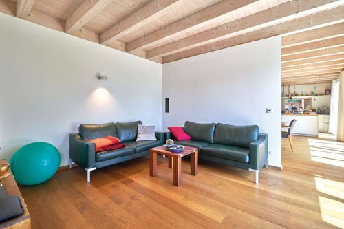Das Wohnzimmer des modernen Holzhauses mit Lärchenholzfassade und Fassadenplatten in anthrazit