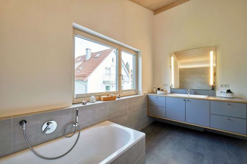 Das Badezimmer des modernen Holzhauses mit Lärchenholzfassade und Fassadenplatten in anthrazit
